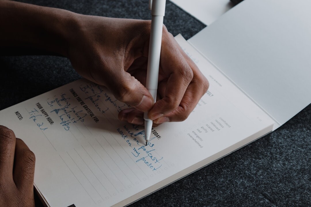person writing in notebook